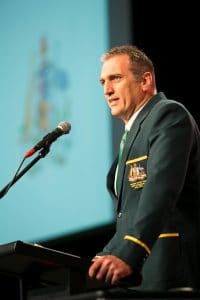 a picture of Mick Colliss speaking at a lectern